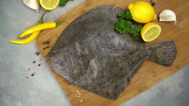 Raw flounder fish with spices. Seafood on a black stone background. Top view. — Stock Video