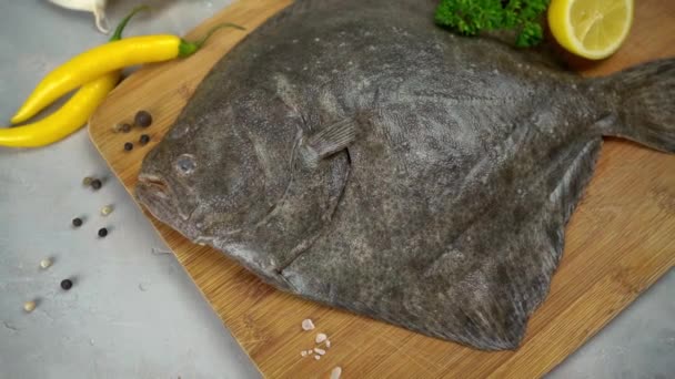 Rå skrubbe fisk med krydderier. Fisk og skaldyr på sort stenbaggrund. Set fra oven. – Stock-video