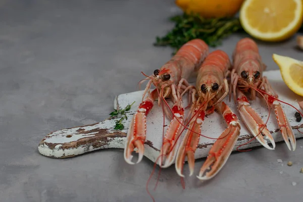 Langoustines Hervidos Sobre Tabla Cortar Blanca Aislada Sobre Mesa Hormigón — Foto de Stock