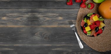 Taze meyve salatası, ahşap arka planda bir kasenin üst görüntüsü, vejetaryen yemek konsepti. BIO meyveleri