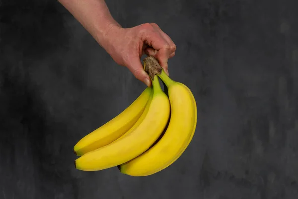 Mão Homem Segura Monte Bananas Fundo Escuro — Fotografia de Stock