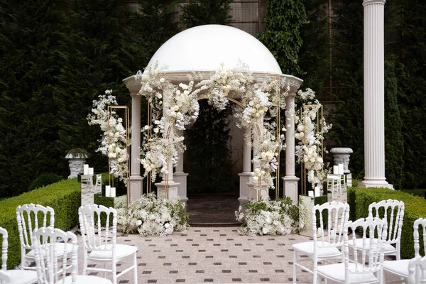 Wedding arch with white and pink roses. The arch is decorated with flowers. Wedding decor.