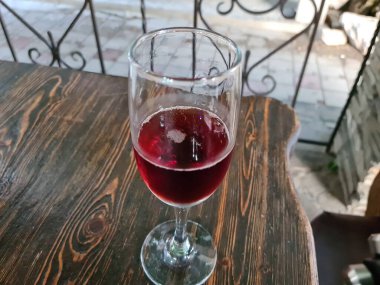 Yakın plan bir kafede masanın üstünde bir kadeh kırmızı şarap.