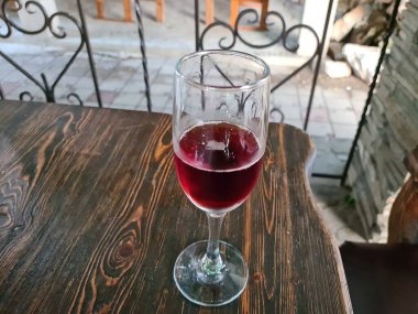 Kafedeki masada bir kadeh kırmızı şarap.