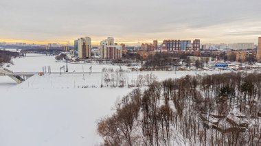 Buzlu nehir ve yüksek binalar boyunca bir kuadkopter kullanarak yükseklikten bir manzara var.
