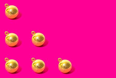 Neon parlak pembe arka plana karşı klasik altın takılardan yapılmış Noel yaratıcı deseni. Yeni yıl ve kış tatili 80 'ler ya da 90' ların süslemeleri ile estetik konsepti.