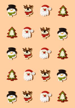Süslemelerle yaratılmış yaratıcı Noel deseni: Ren geyiği, kardan adam, Noel Baba ve pastel şeftali üzerine noel ağacı, mercan arka plan. Minimum eğlence ve mutlu kış tatilleri ve yeni yıl fikri.