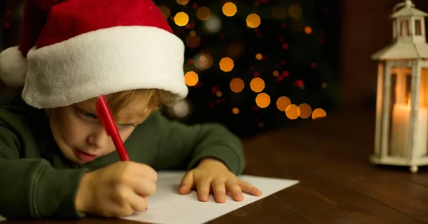 Boy Christmas Hat Escribe Una Carta Santa Claus Luz Una — Foto de Stock
