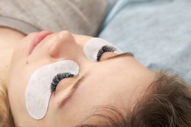 Uzatma işleminden sonra kirpikleri kapat. Kirpik uzatma için yapılan kozmetik prosedürünün sonucu