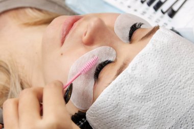 Kirpik uzatma işleminden sonra fırça kullanarak bir görünüm oluşturma işlemi.