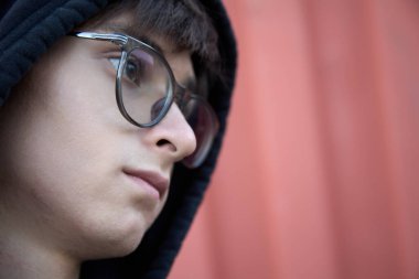 Siyah başlıklı beyaz bir genç boş bakışlarla bir yerlerde bizi izliyor.. 