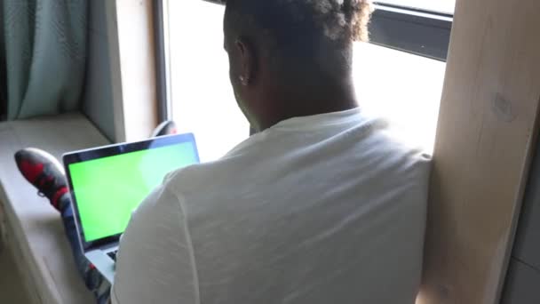 Il ragazzo nero usa un portatile, lavora da remoto, naviga sulla rete globale — Video Stock