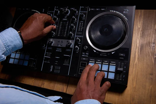 Black man DJ maakt gebruik van control desk om lied te maken. — Stockfoto
