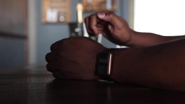 Achter de bar, een zwarte man in een slim horloge maakt een bestelling — Stockvideo