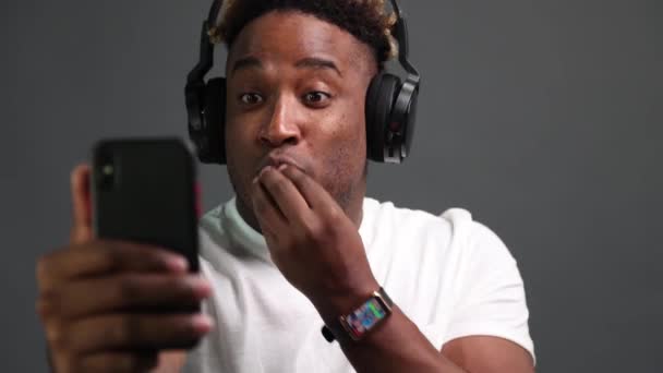 Afrikaner mit drahtlosen Kopfhörern nutzt Smartphone für Videoanrufe — Stockvideo