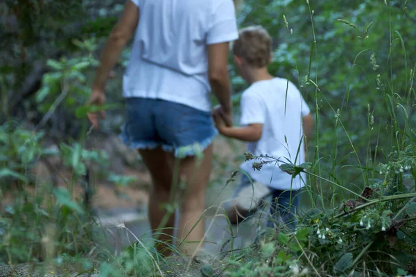 Woman and a child go deep into the mysterious jungle holding hands. — Stock Photo, Image