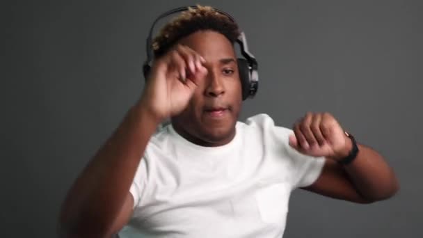 Black African American man listens to music with headphones and dances. — Vídeo de Stock