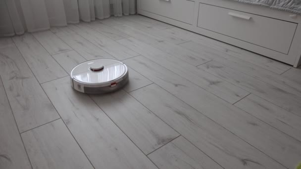 4k video robot stofzuiger reinigt een mooi laminaat in de kamer — Stockvideo