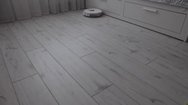 Modern robot elektrik süpürgesi yatak odasının zeminini süpürüyor..