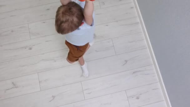 Vista dall'alto di un bambino carino che gira a casa sugli anelli ginnici. — Video Stock
