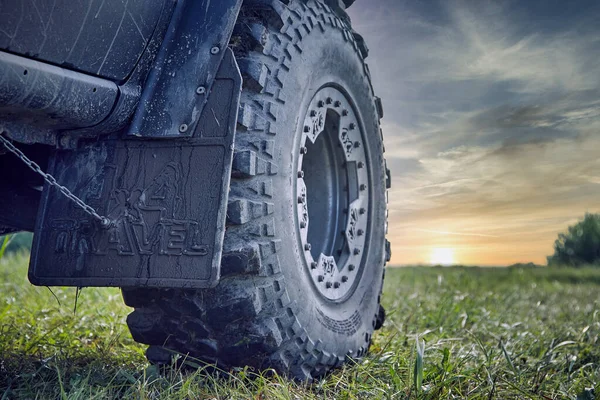 Coche todoterreno salpicado de barro contra un hermoso cielo. — Foto de Stock