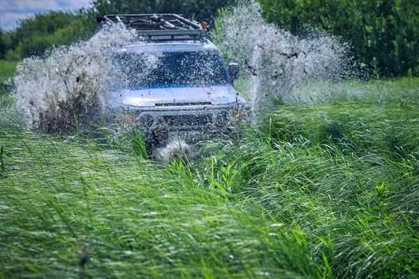 Voiture tout-terrain s'est écrasé dans une flaque d'eau et a soulevé des éclaboussures de boue. — Photo