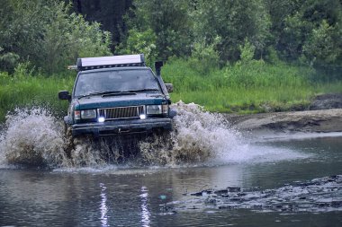 4x4 off-road arabası yüksek hızla su bariyerini geçiyor.. 