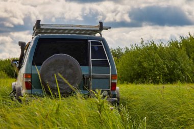 Vahşi doğada bir 4x4 SUV 'un arka görüntüsü. Seyahat ve macera kavramı