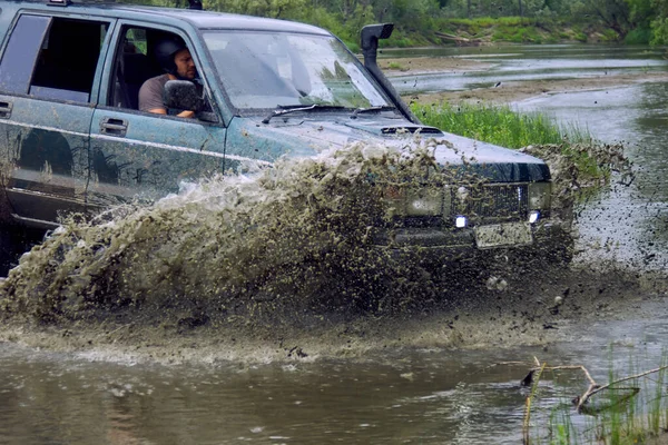 4x4 off-road car crosses a water barrier with splashes at high speed. — Stock Photo, Image