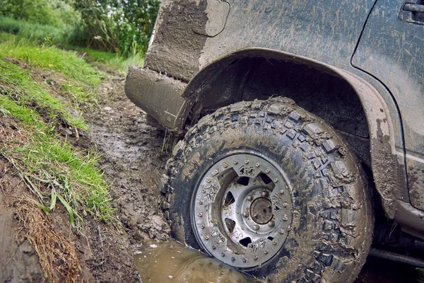 Very dirty 4x4 off-road car slides down the slope into a large puddle — Stock Photo, Image