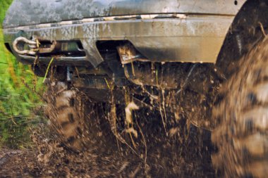 Arazi aracının tekerlekleri çamurda kayıyor, araba off-road 'da sıkışıyor.