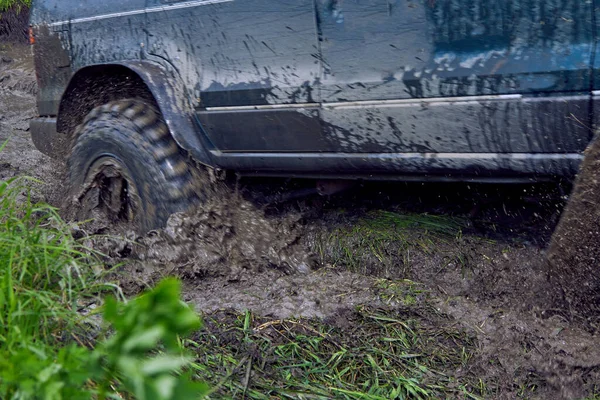 Offroader stalled in the mud during an off-road race, wheels slip on slush — Stock Photo, Image
