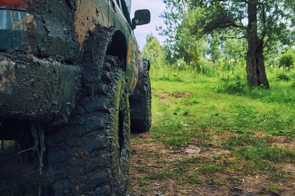 Dirty SUV staat op het gazon na een off-road race, bedekt met slush — Stockfoto