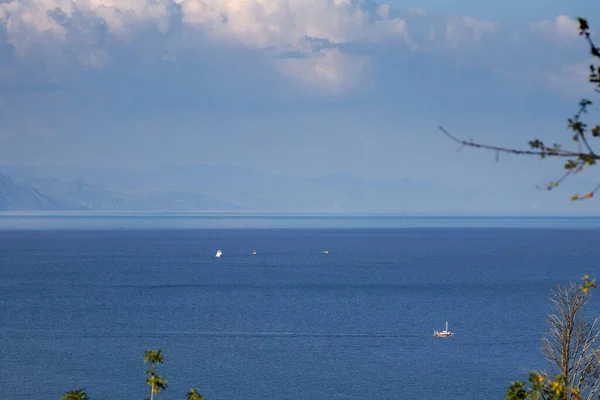Schönes blaues Meer, auf dem Schiffe fahren, in der Ferne sieht man Berge. — Stockfoto