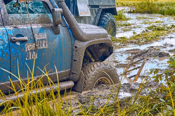 4x4 SUV preso em um pântano durante competições extremas é puxado para fora usando um guincho — Fotografia de Stock