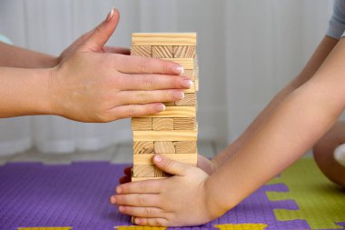 Oğlan ve annesi jenga kulesini bir araya getirip ellerini dikkatlice temizlediler.