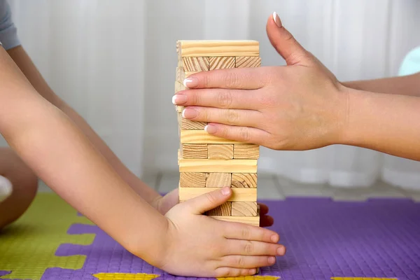 Boy and his mother put the jenga tower together and clean their hands carefully — Stock Photo, Image