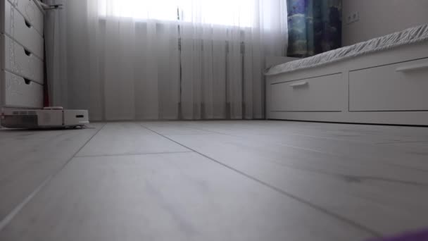 Robot aspiradora para un hogar inteligente que elimina el polvo de un piso laminado — Vídeos de Stock