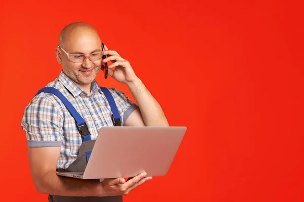 Skallig Man Arbetsdräkt Och Glasögon Pratar Telefon Och Tittar Bärbar — Stockfoto