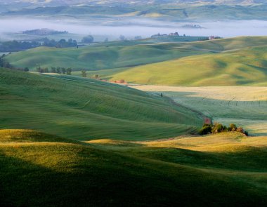 Bahar Tuscany. Güneşli tepelerin manzarası. Vadide sis var..