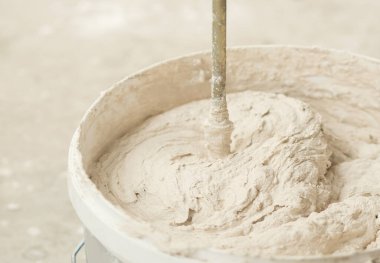 Alçı havan macunu karıştırıcısını yakın çekim kovasına karıştırma işlemi