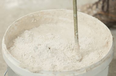 Alçı havan macunu karıştırıcısını yakın çekim kovasına karıştırma işlemi