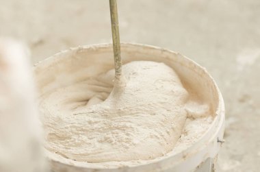 Alçı havan macunu karıştırıcısını yakın çekim kovasına karıştırma işlemi