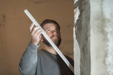 Sakallı bir adam. Sıvacı tutan bir adam.