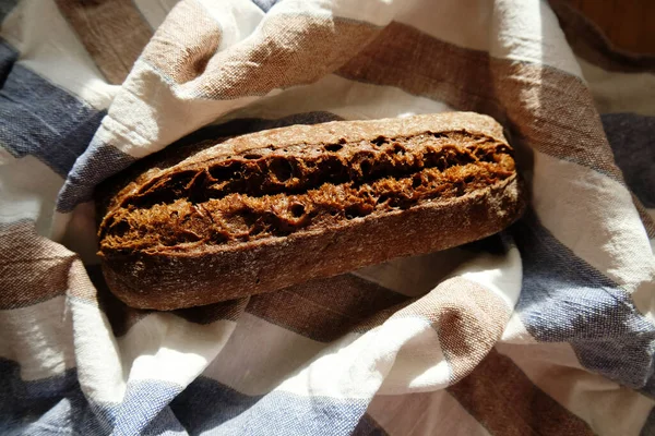 Pan de baguette de centeno recién horneado sobre una toalla de lino —  Fotos de Stock