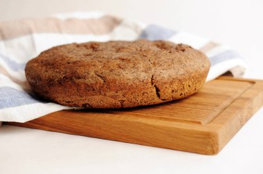 Tahta üzerinde taze ev yapımı malt çavdar ekmeği, keten kumaş. Beyaz arkaplanda