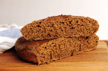 Tahta üzerinde taze ev yapımı malt çavdar ekmeği, keten kumaş. Beyaz arkaplanda