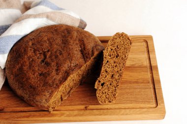 Tahta üzerinde taze ev yapımı malt çavdar ekmeği, keten kumaş. Beyaz arkaplanda