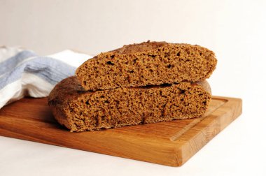 Tahta üzerinde taze ev yapımı malt çavdar ekmeği, keten kumaş. Beyaz arkaplanda