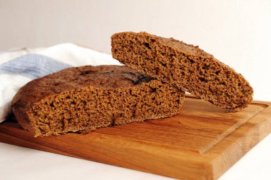 Tahta üzerinde taze ev yapımı malt çavdar ekmeği, keten kumaş. Beyaz arkaplanda